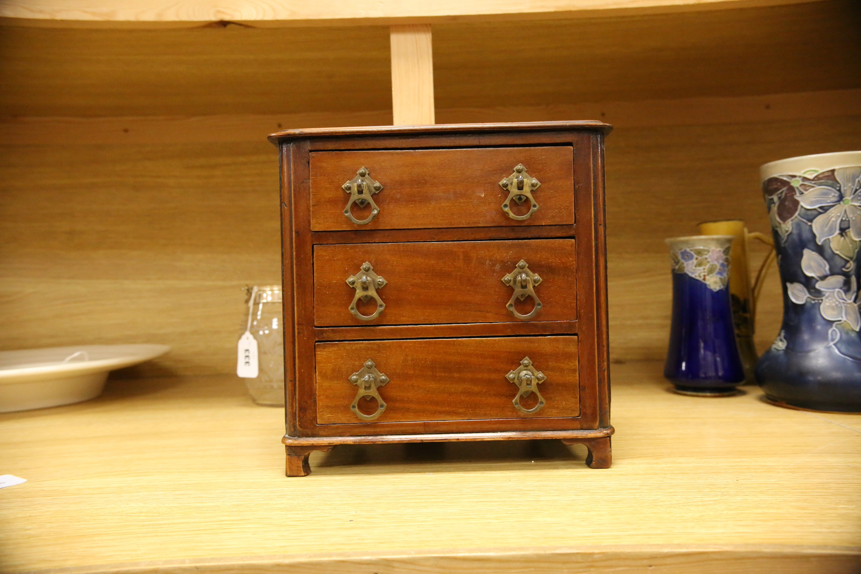 An Edwardian miniature mahogany three drawer chest, 26cm wide x 28cm high. Condition - fair to good